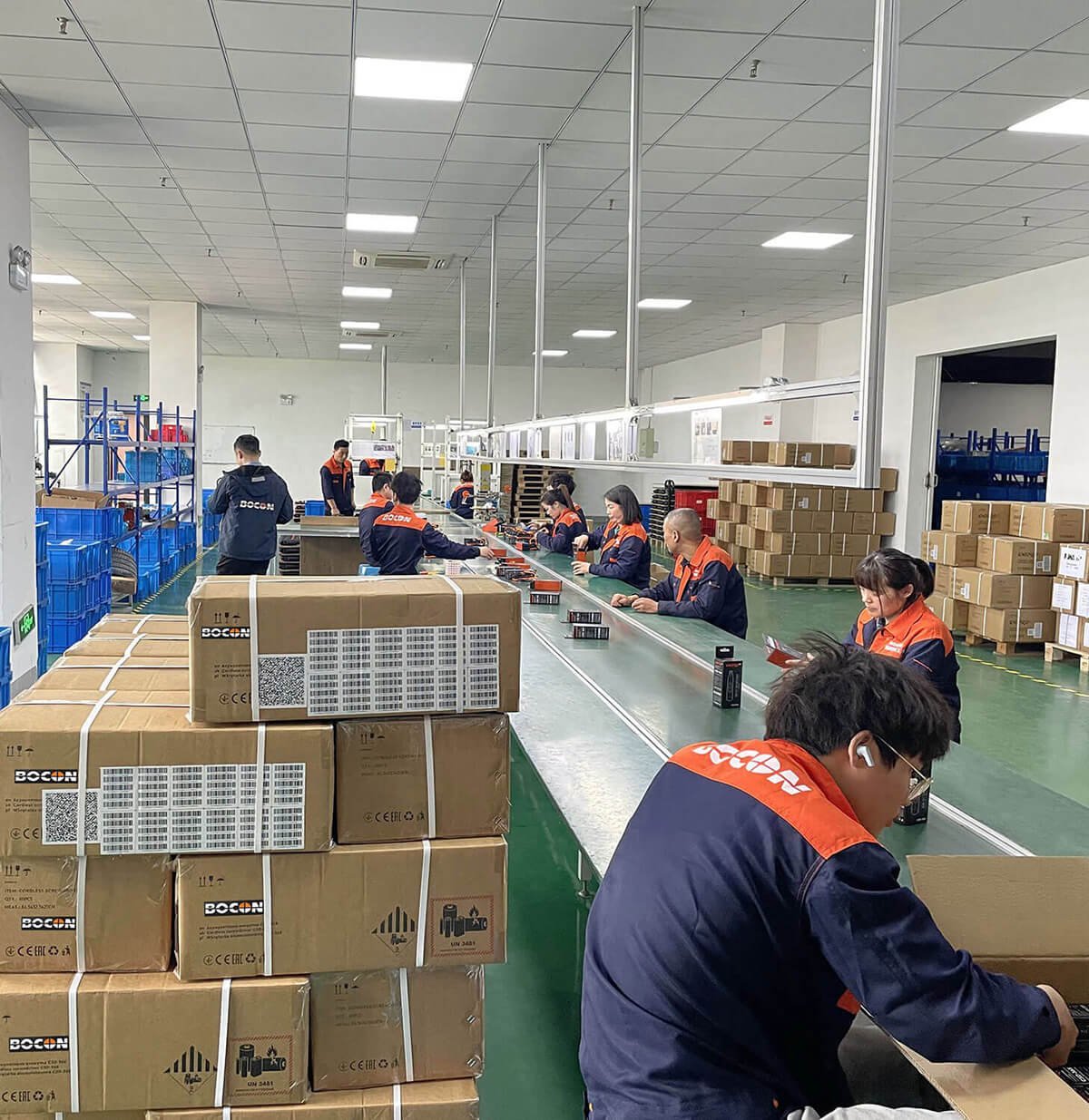 Cordless power tool assembly line at Bocon's OEM factory — workers packing UN 38.3 certified battery kits for export